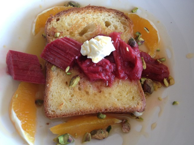 Brioche French toast with vanilla poached rhubarb and fresh orange segments topped with homemade labne and toasted pistachio